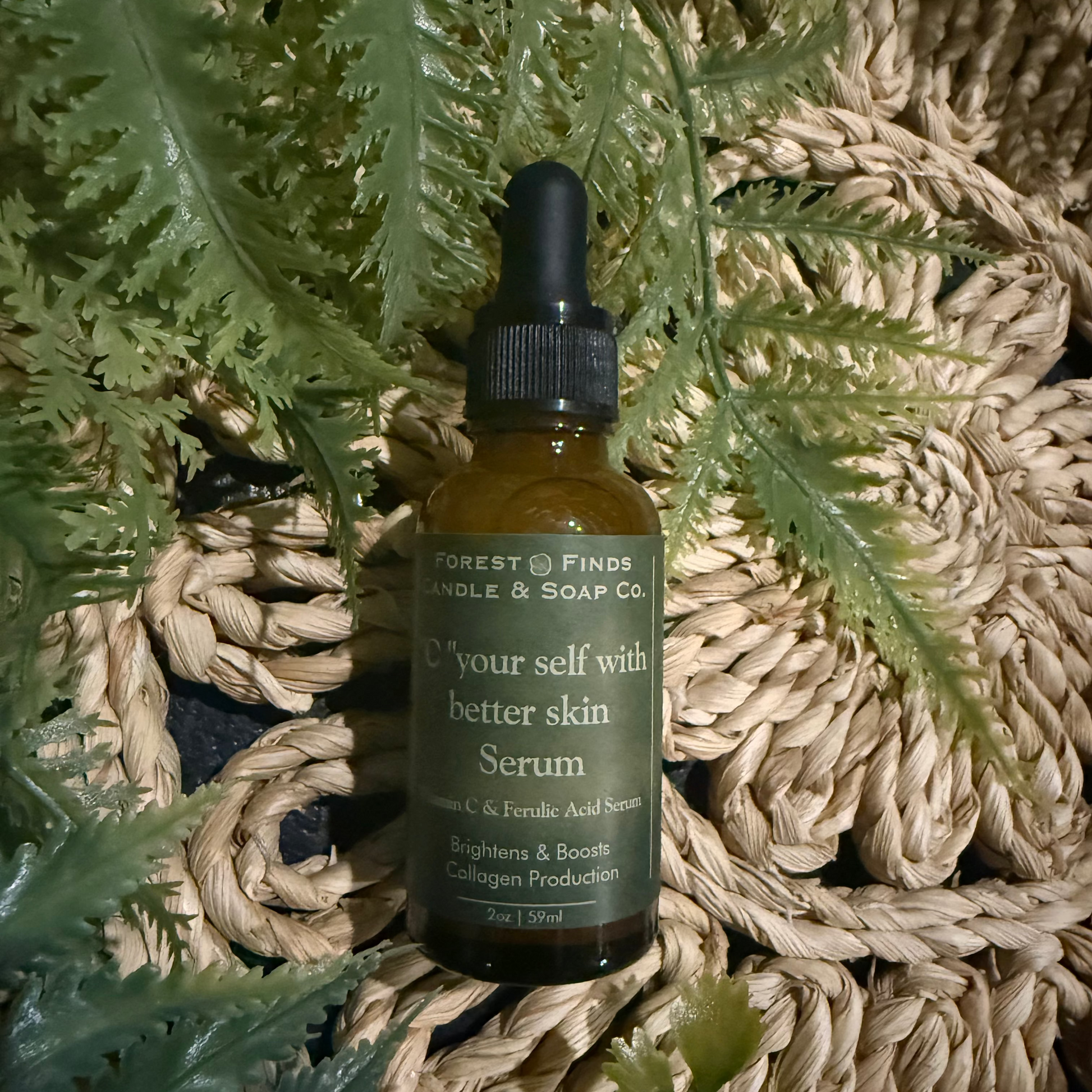 Serum bottle with green label on a textured surface with ferns